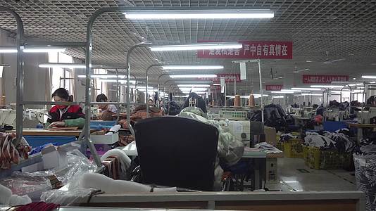 服装厂制衣车间工人缝纫衣服视频的预览图