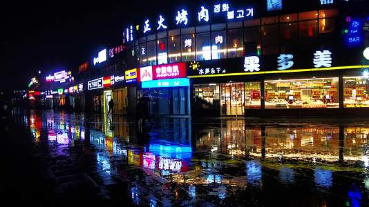 雨夜冷清的餐饮街打伞的行人视频的预览图