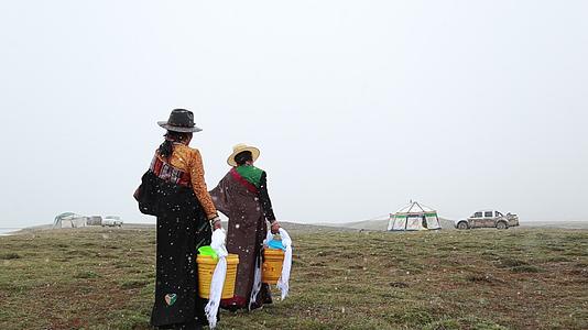 青海省三江源牧区藏族妇女打水日常生活视频的预览图