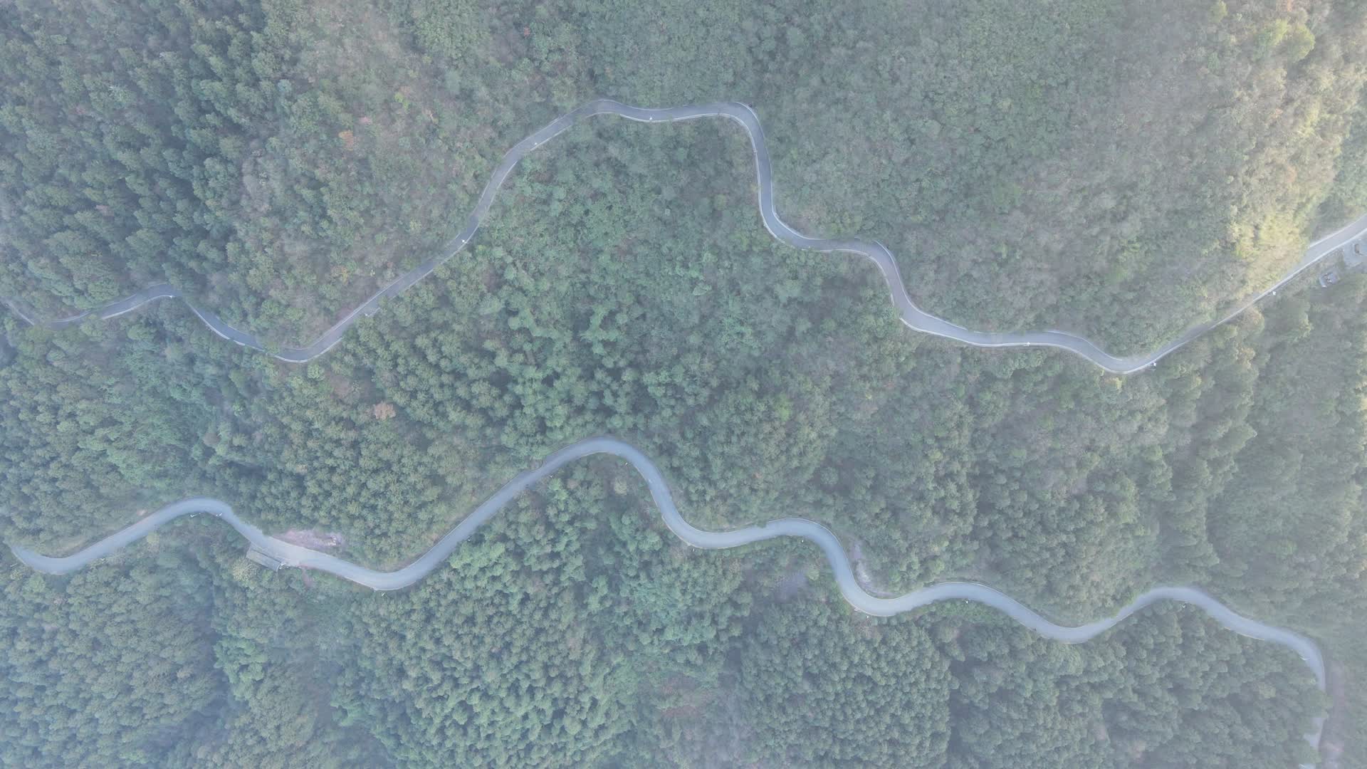 航拍绿色森林蜿蜒盘山公路视频的预览图