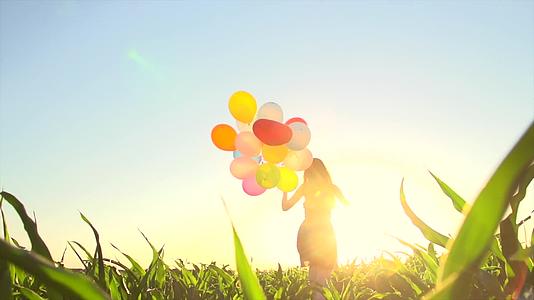 女孩拿气球田地快乐奔跑视频视频的预览图