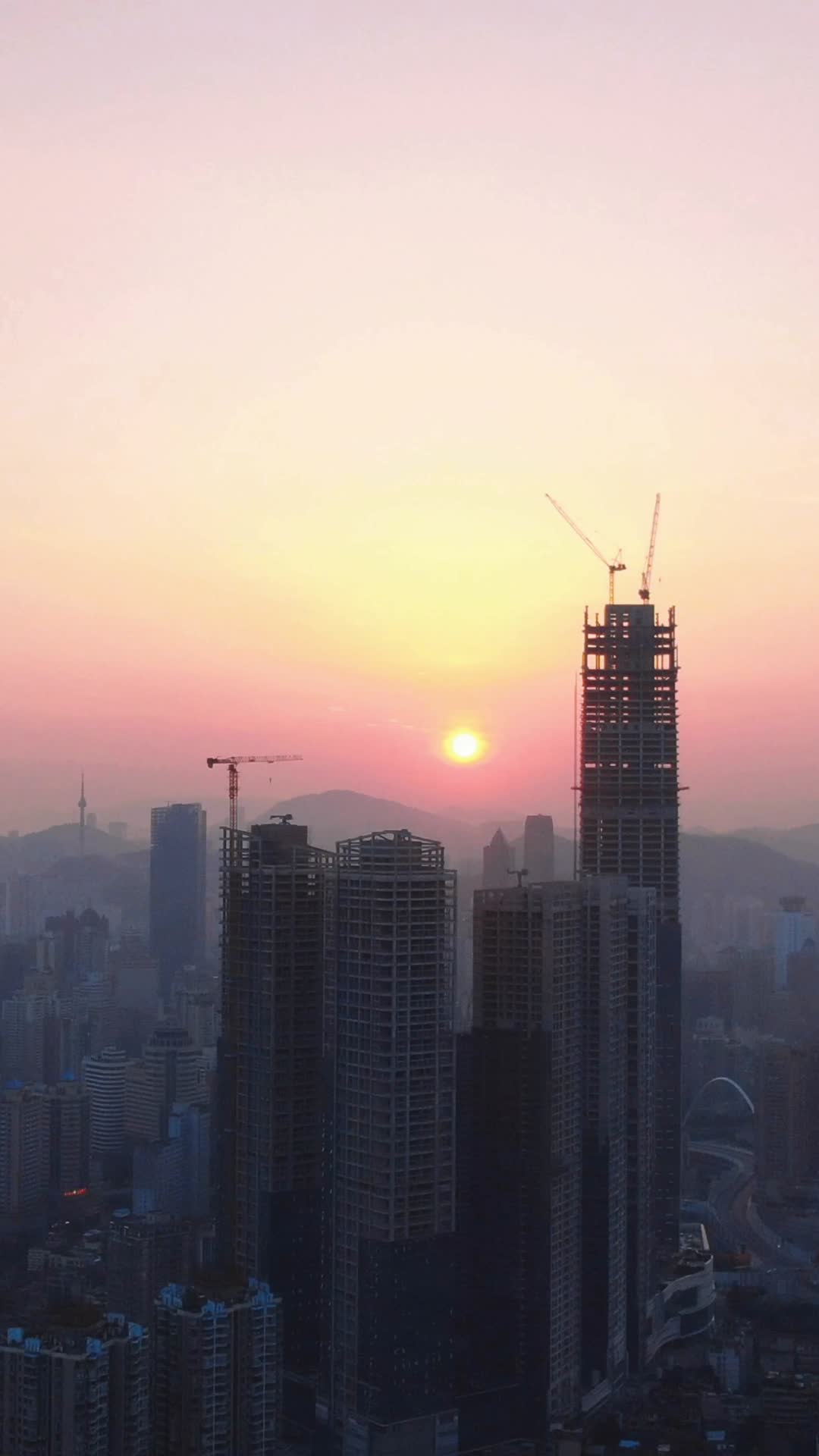 城市高楼吊塔日出竖屏航拍视频的预览图