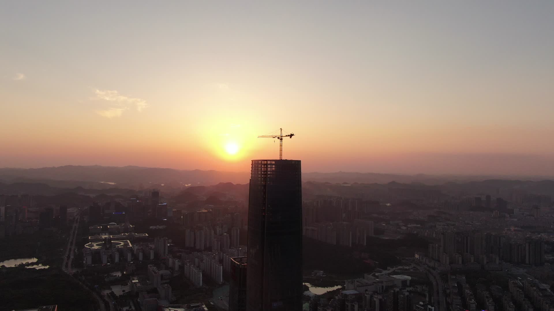 航拍城市高楼吊塔日落晚霞视频的预览图