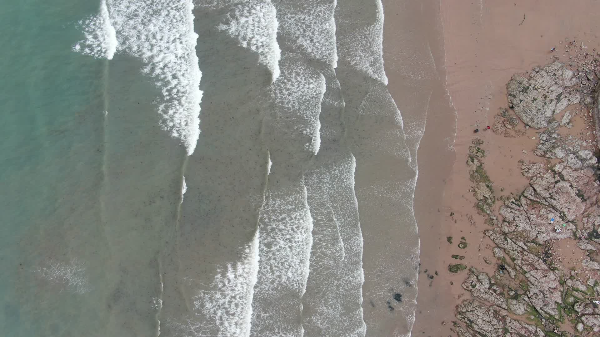 航拍山东青岛海滩沙滩大海海浪礁石视频的预览图