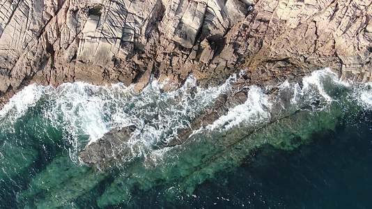航拍蓝色海洋海浪拍打礁石视频的预览图