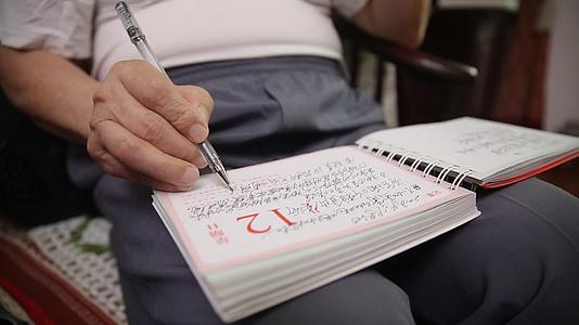 老人看书记笔记写字视频的预览图