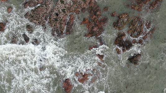 俯拍大海海浪拍打礁石视频的预览图