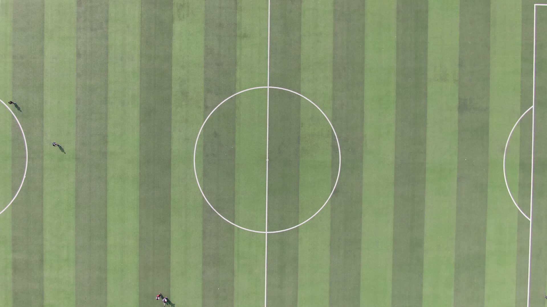 俯拍校园操场学生运动踢足球视频的预览图