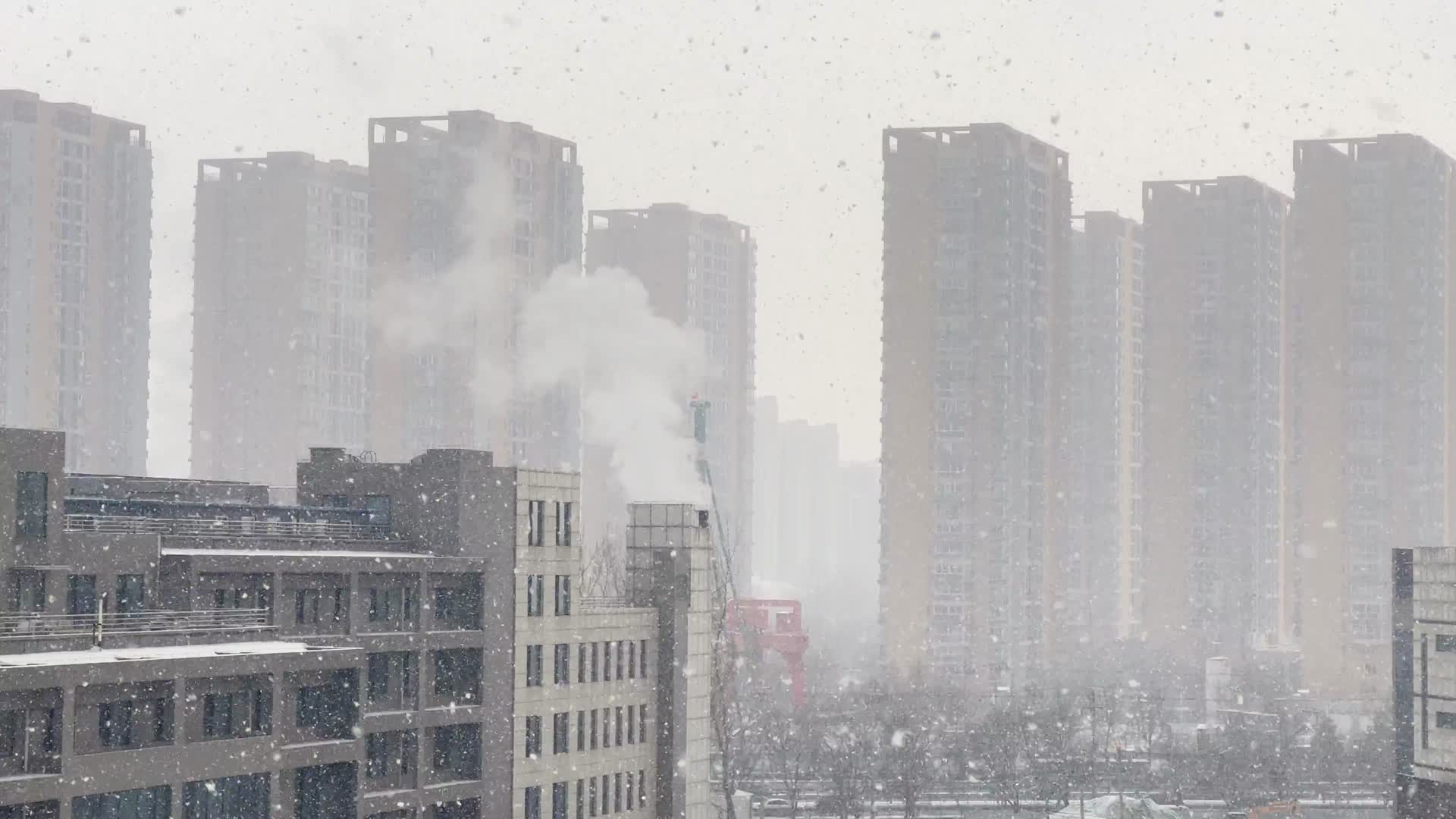 冬季里的城市灰色下雪雪中楼宇建筑烟筒视频的预览图