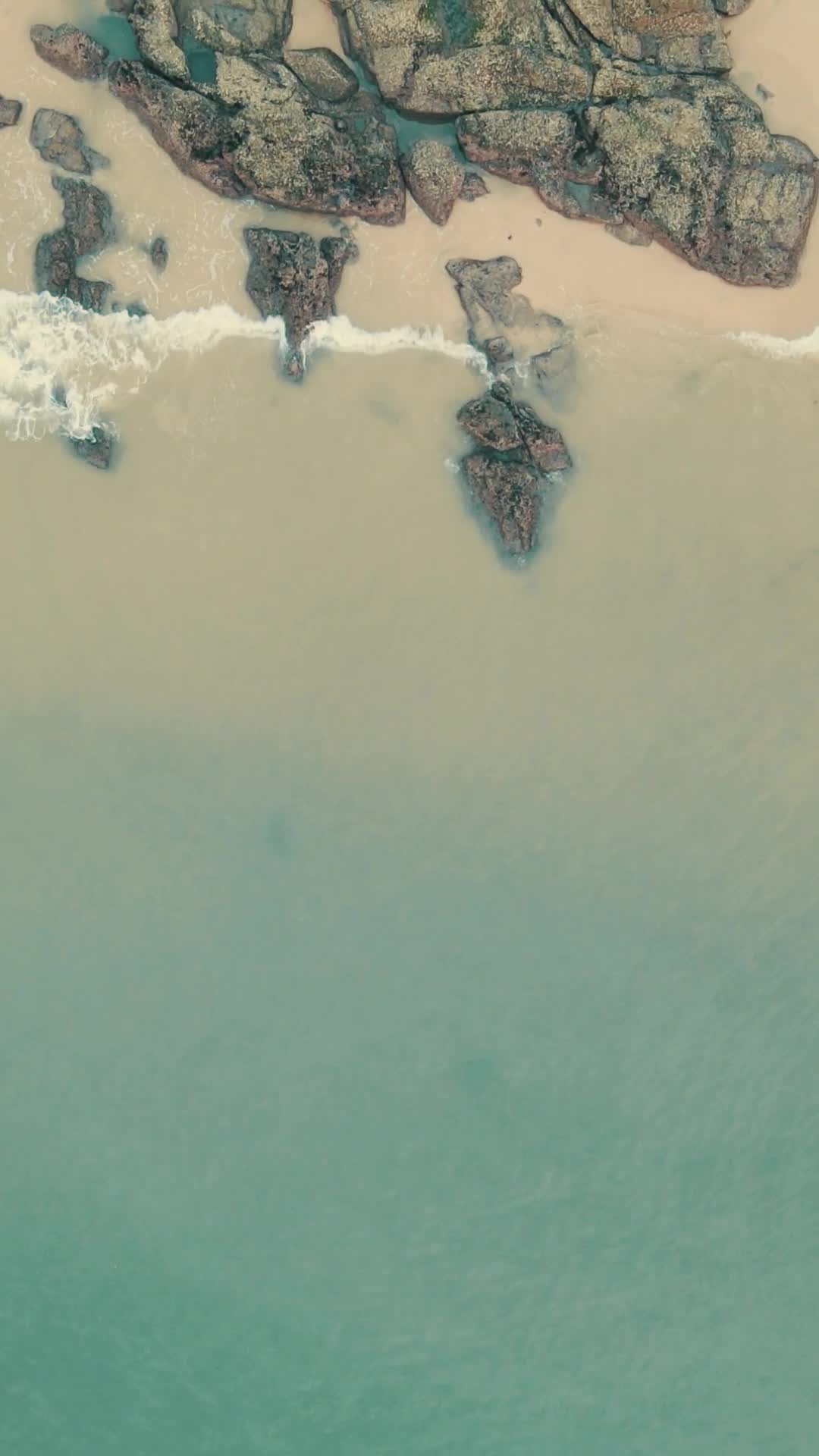 航拍大海海浪礁石沙滩竖屏视频的预览图