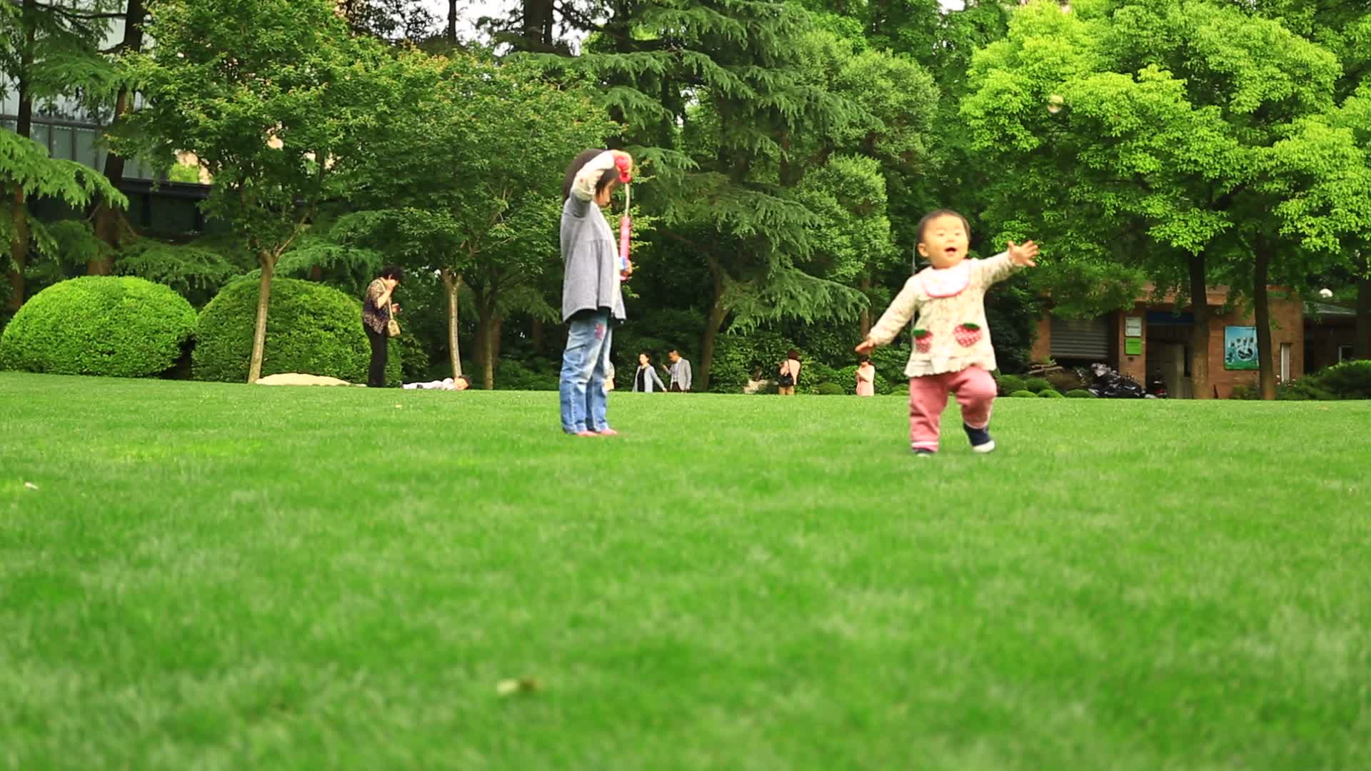 公园草坪儿童玩耍追泡泡视频的预览图