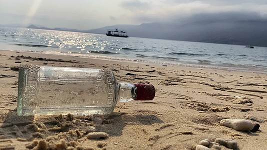 海边沙滩空酒瓶转场短视频拍摄视频的预览图
