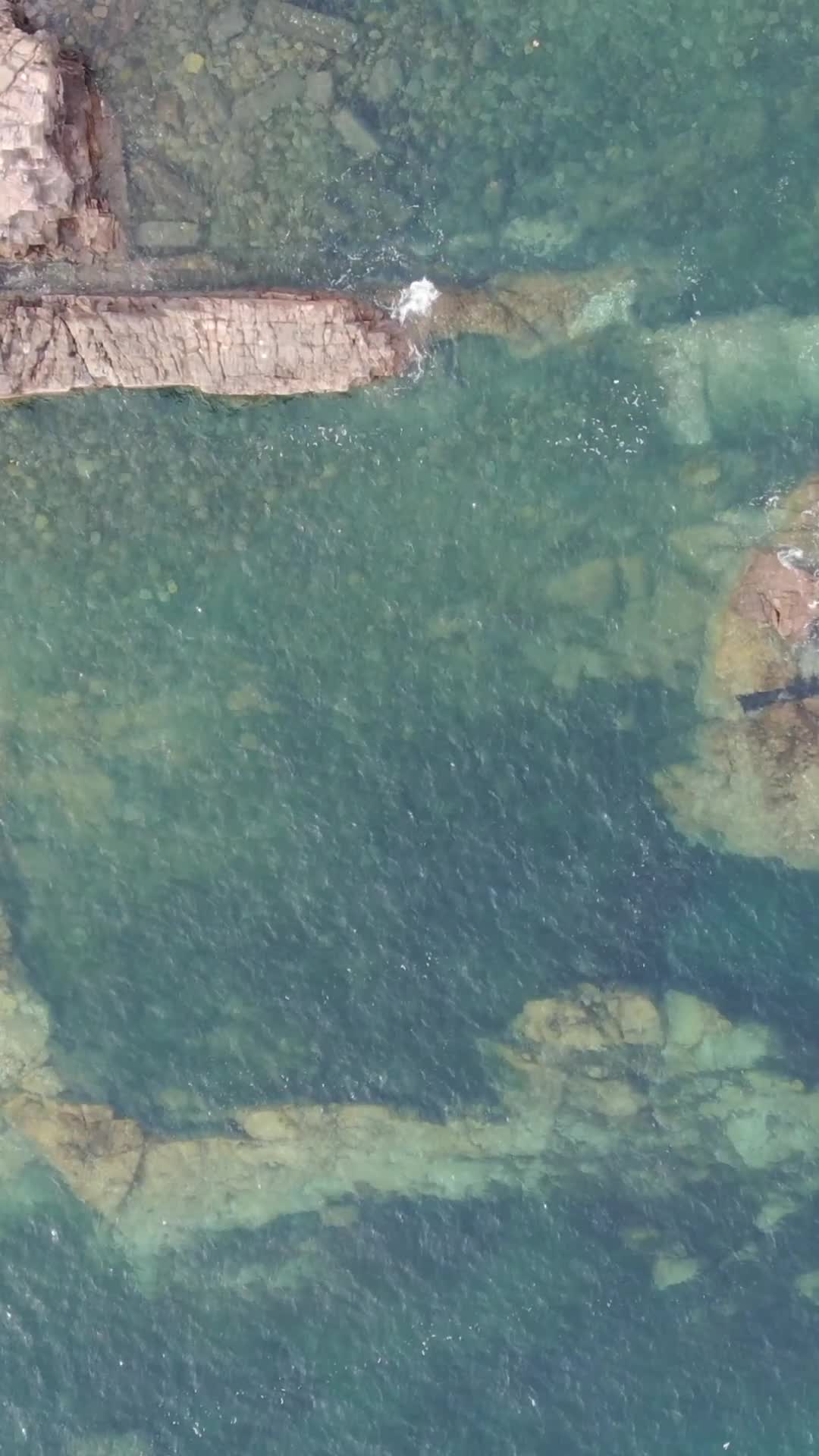 俯拍蓝色海洋礁石海浪视频的预览图