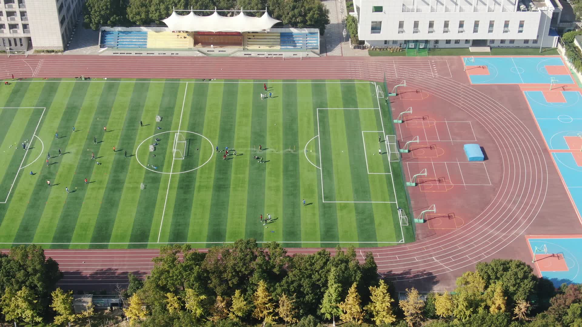 航拍校园运动场踢足球运动视频的预览图