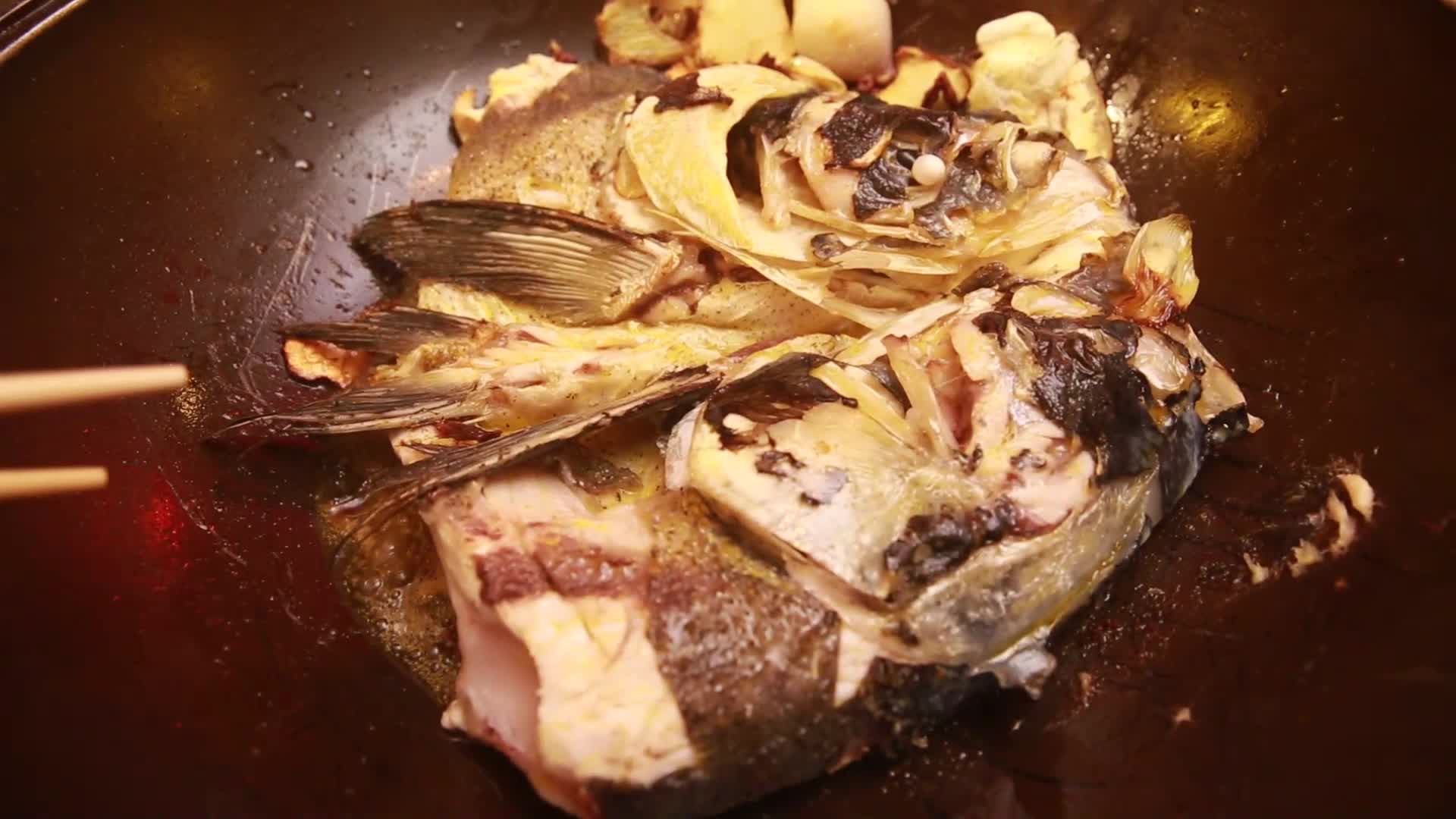 镜头合集铁锅柴锅炖鱼头视频的预览图
