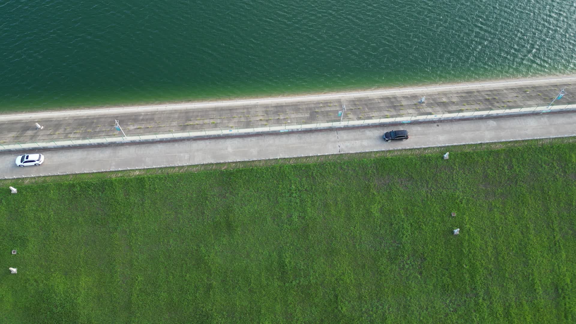 航拍行驶在水库大坝的汽车视频的预览图