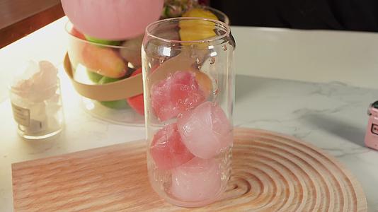 玻璃杯放入玫瑰冰块倒入玫瑰沙冰冷饮视频的预览图