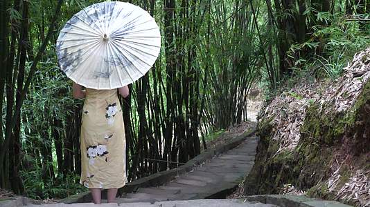 古镇美女背影竹林间行走油纸伞古典美女休闲散步慢动作视频的预览图