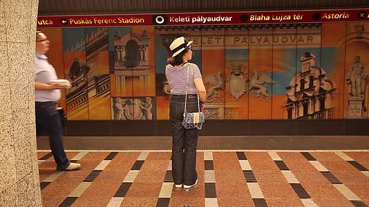 站在欧洲地铁站台的亚洲女性旅行者背影视频的预览图