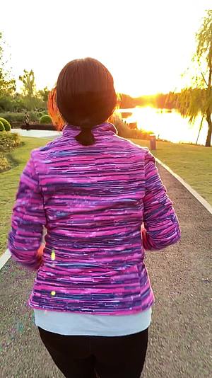 黄昏在户外公园跑步健身的女人背影视频的预览图