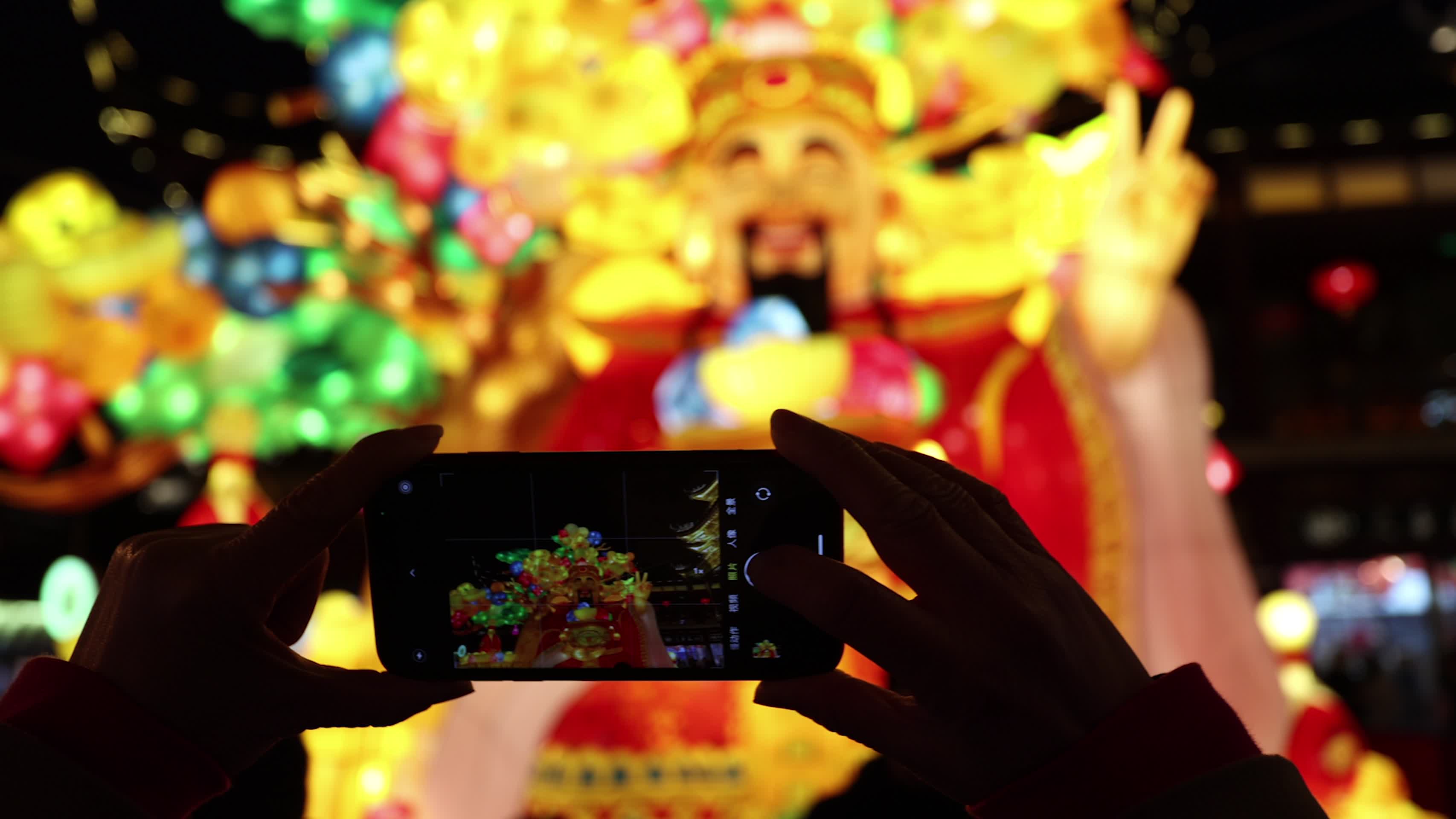 豫园灯会市民用手机拍摄财神花灯视频的预览图