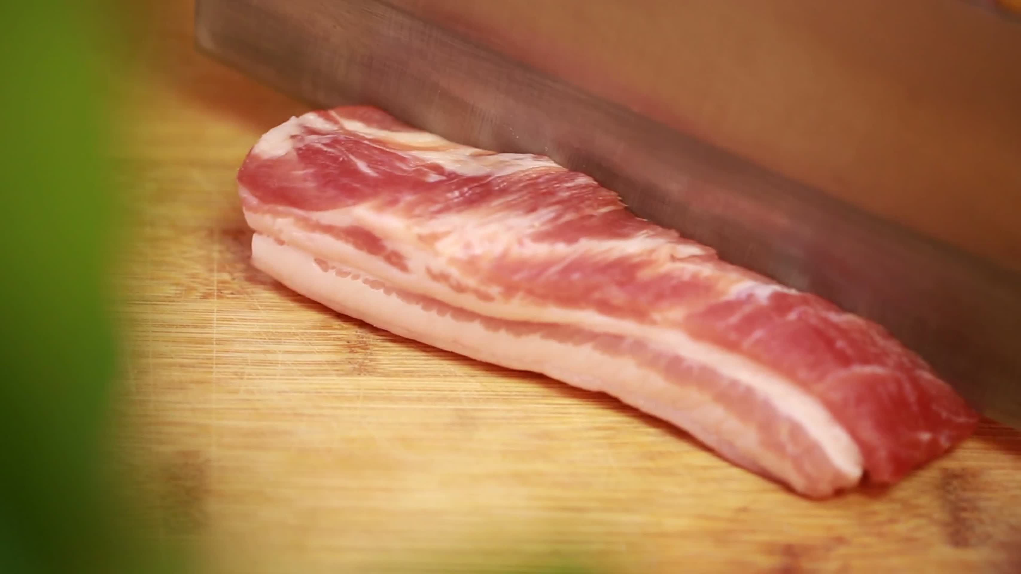 美食镜头合集菜刀切五花肉块视频的预览图