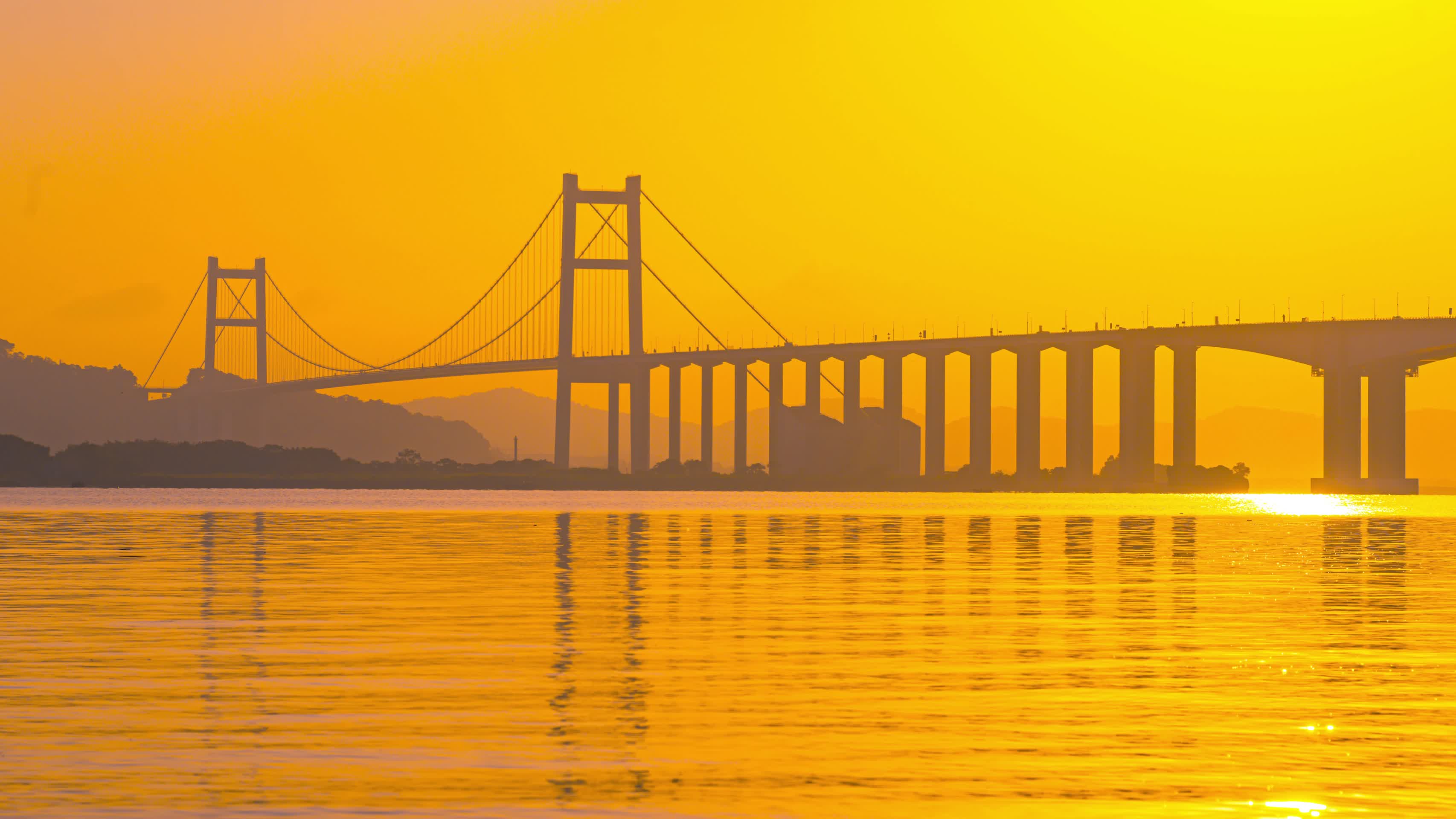 8K唯美海平面跨海大桥倒影金色光芒映照海面延时视频的预览图