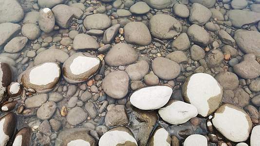 河岸水花拍打鹅卵石清澈见底背景视频的预览图