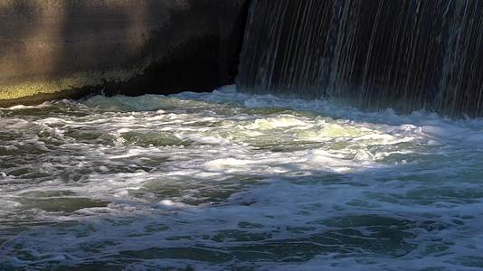 阳光照射下的湍急的水坝水流视频的预览图