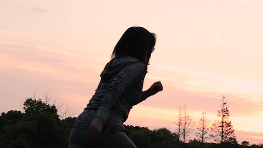 黄昏在户外田野奔跑的女人背影慢镜头视频的预览图