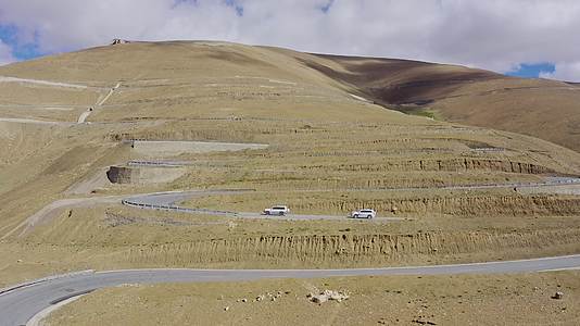 航拍越野车行驶在西藏珠峰108拐盘山公路视频的预览图