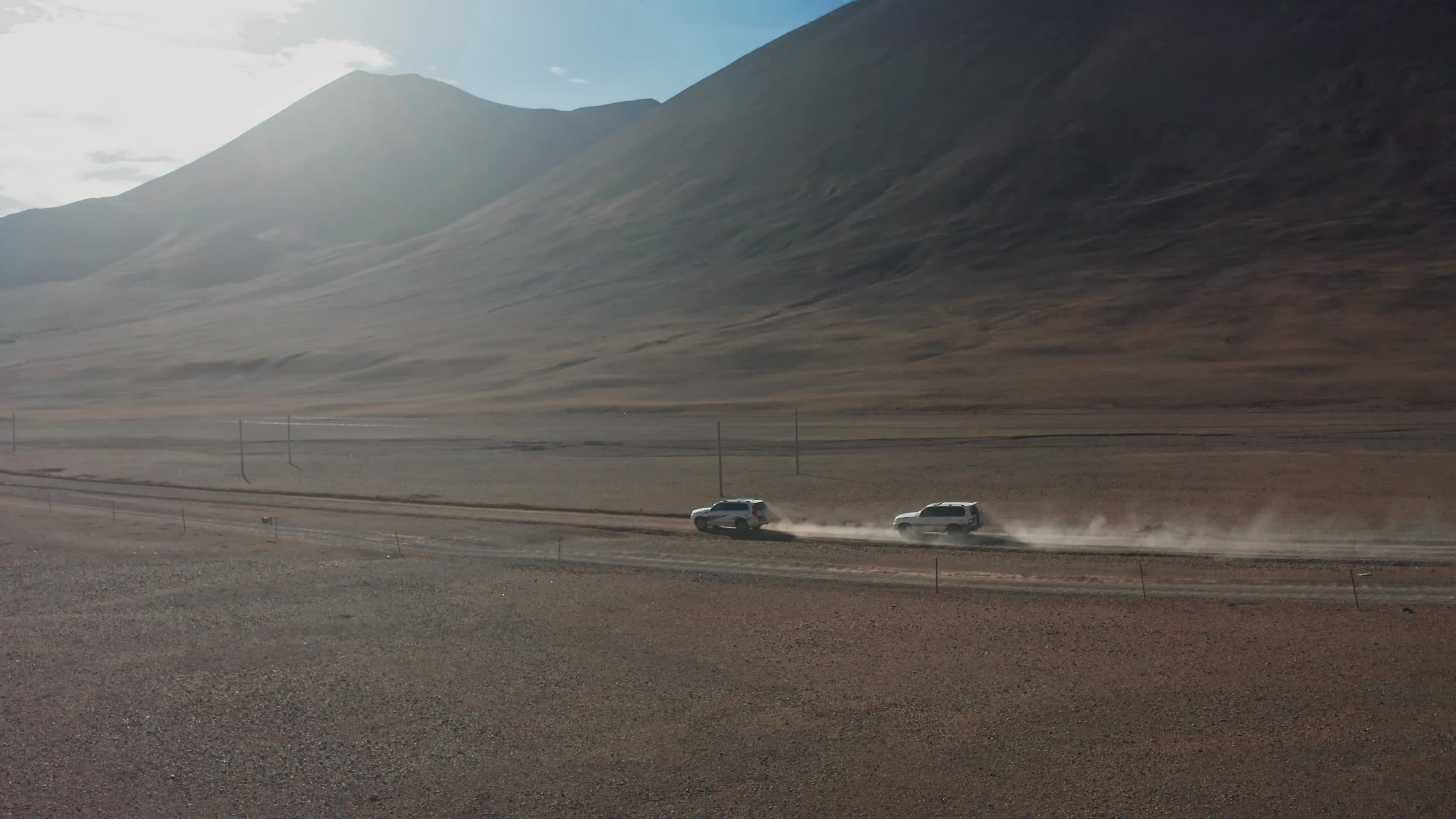 航拍越野车行驶在西藏阿里无人区的荒漠中车后扬起尘烟视频的预览图