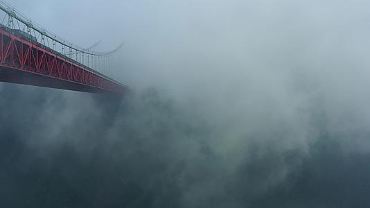 航拍雨雾中的矮寨大桥和德夯大峡谷风光视频的预览图