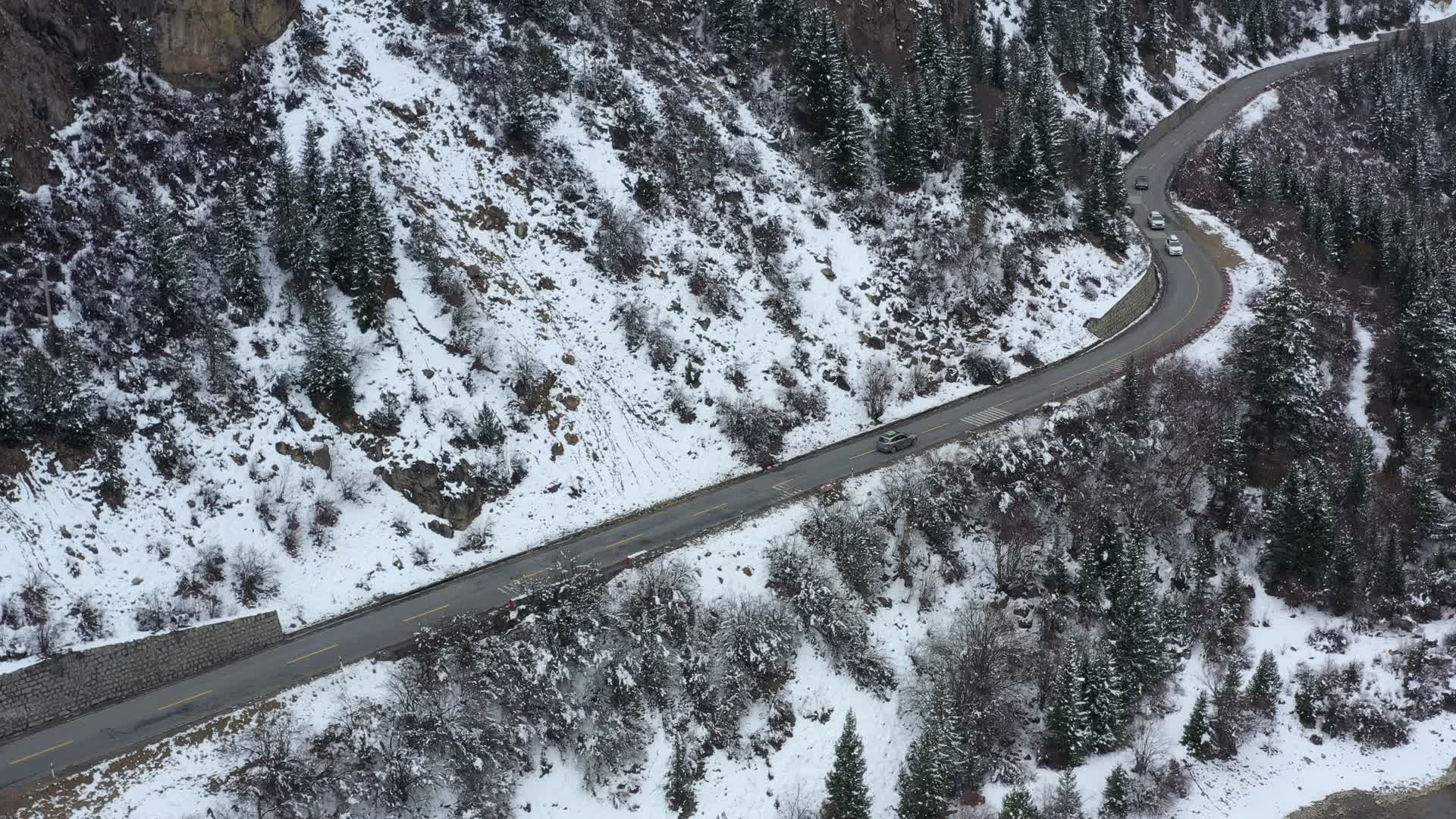 汽车行驶在下雪天帕隆藏布江河谷的川藏公路视频的预览图