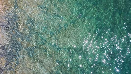 航拍清澈的纳木错湖水和水底礁石湖面波光粼粼视频的预览图