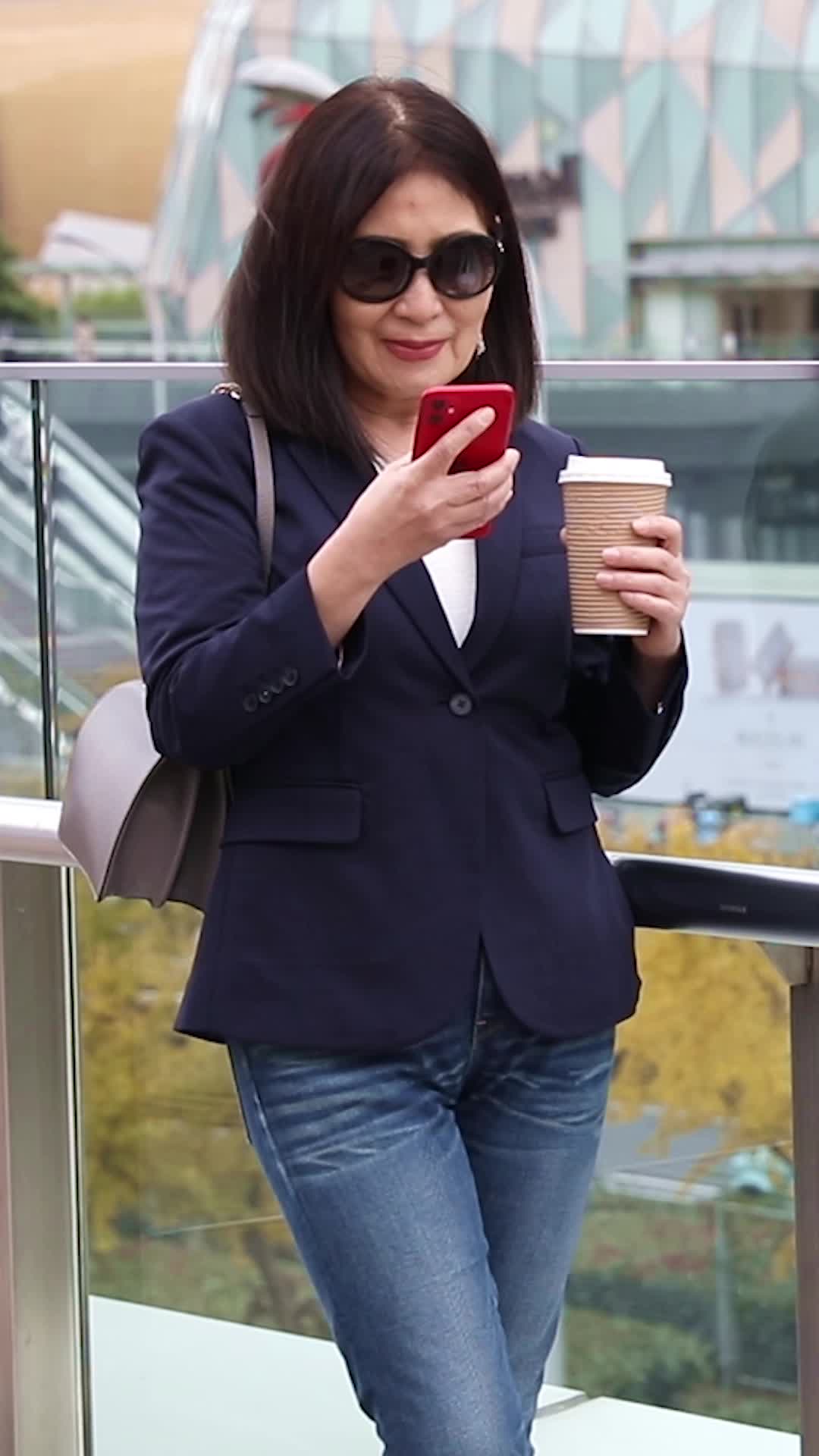 商务女士在户外使用智能手机视频的预览图