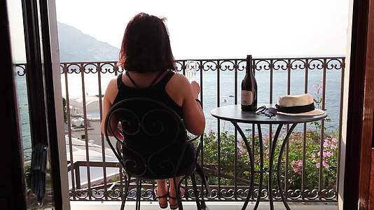 在海边度假酒店阳台喝香槟的女人背影合集视频的预览图