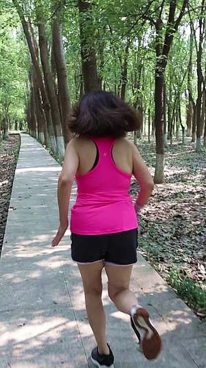 在公园树林跑步的东方女性视频的预览图