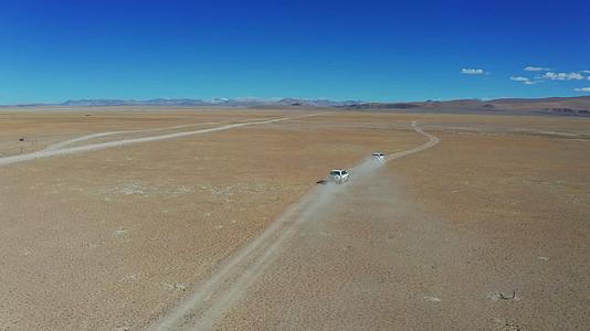 航拍越野车行驶在西藏无人区辽阔的草原上视频的预览图