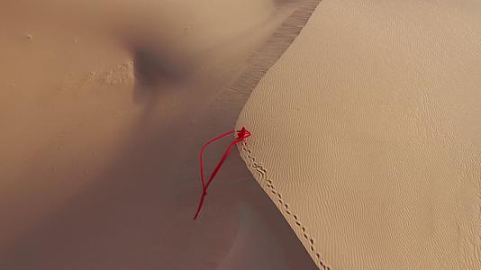 红色超长裙带美女走在巴丹吉林沙漠上视频的预览图