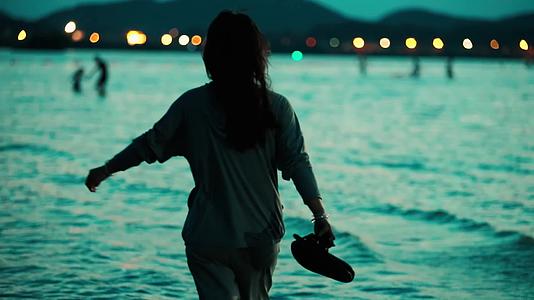 海边漂亮女孩海边散步傍晚沙滩剪影视频的预览图