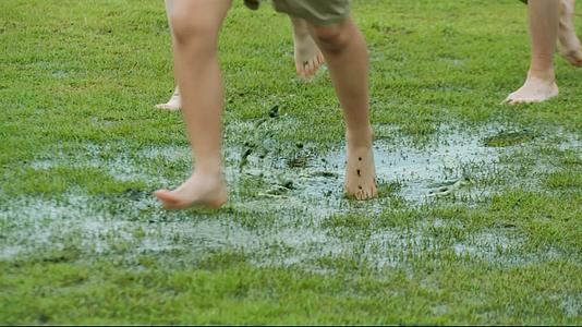 学生奔跑在泥泞的草地上视频的预览图