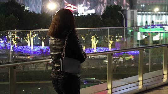 夜晚独自走在城市街道的东方女性背影视频的预览图