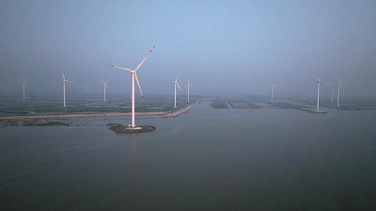 日出时分海边的风力发电机视频的预览图