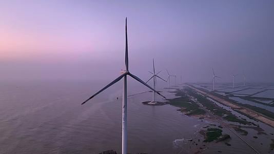 日出时分海边的风力发电机视频的预览图