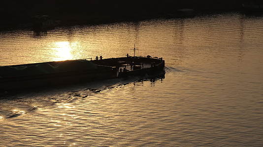 货夕阳下船驶过金色小河4K视频的预览图