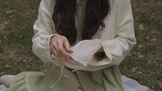 下午公园草地微风女孩湿巾擦手消毒无调色视频的预览图
