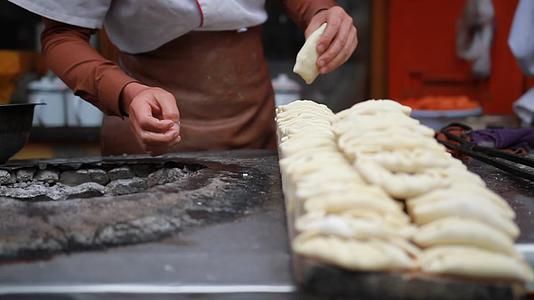 新疆特色美食异域风情小吃制作街边小吃店烤包子实景拍摄视频的预览图