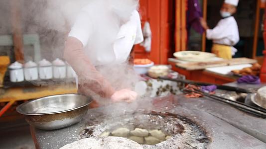 新疆特色美食异域风情小吃制作街边小吃店烤包子实景拍摄视频的预览图