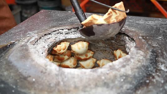 新疆特色美食异域风情小吃制作街边小吃店烤包子美食出炉实景拍摄视频的预览图